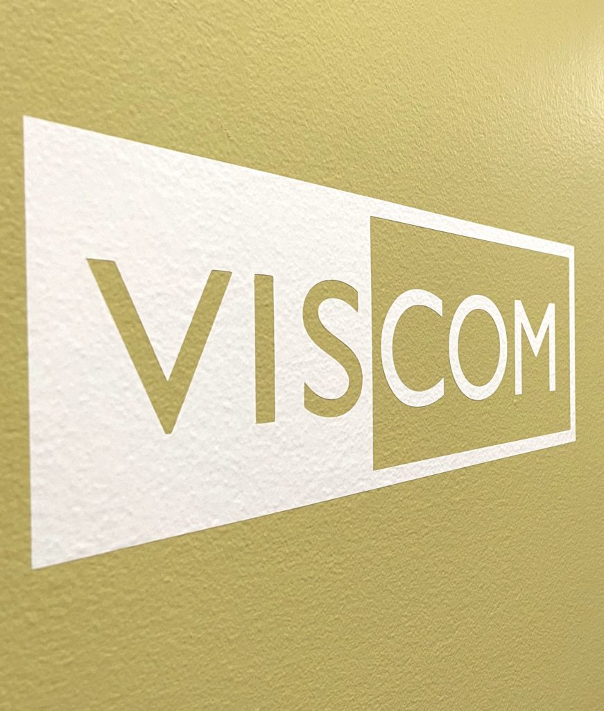VISCOM sign on a wall inside Dallavis Hall