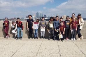 Mooneyham with her class on a rooftop with the KC skyline in the background