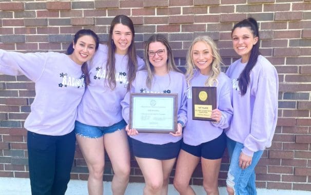5 Avila rad science students in front of a brick wall.
