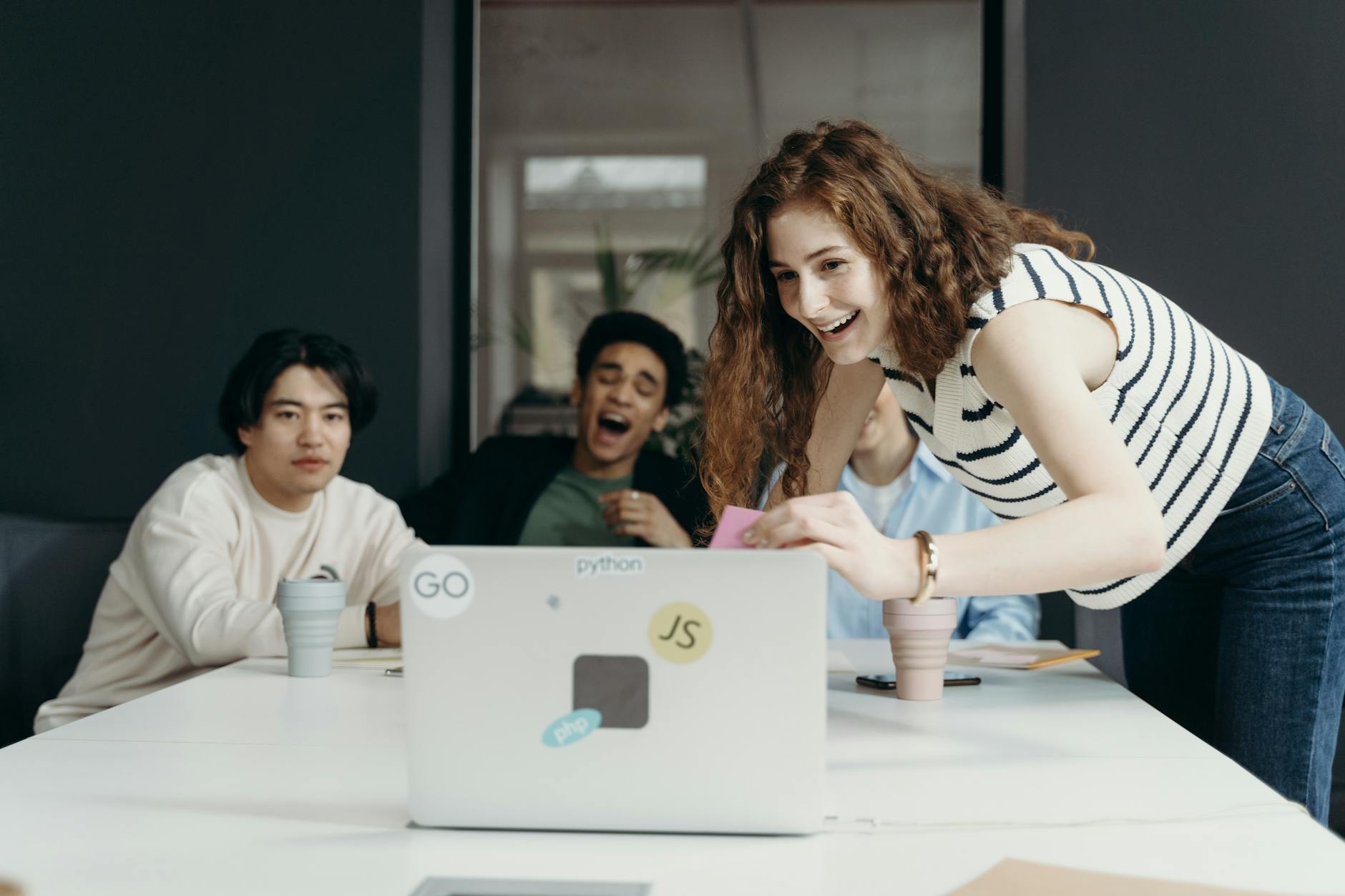 people laughing looking at a laptop