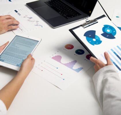 Team analyzing financial charts and digital reports during a business meeting.