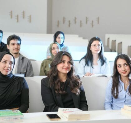 Group of diverse students in a university classroom during a lecture, engaged and attentive.